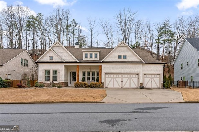 craftsman-style home featuring a garage, a chimney, driveway, and fence