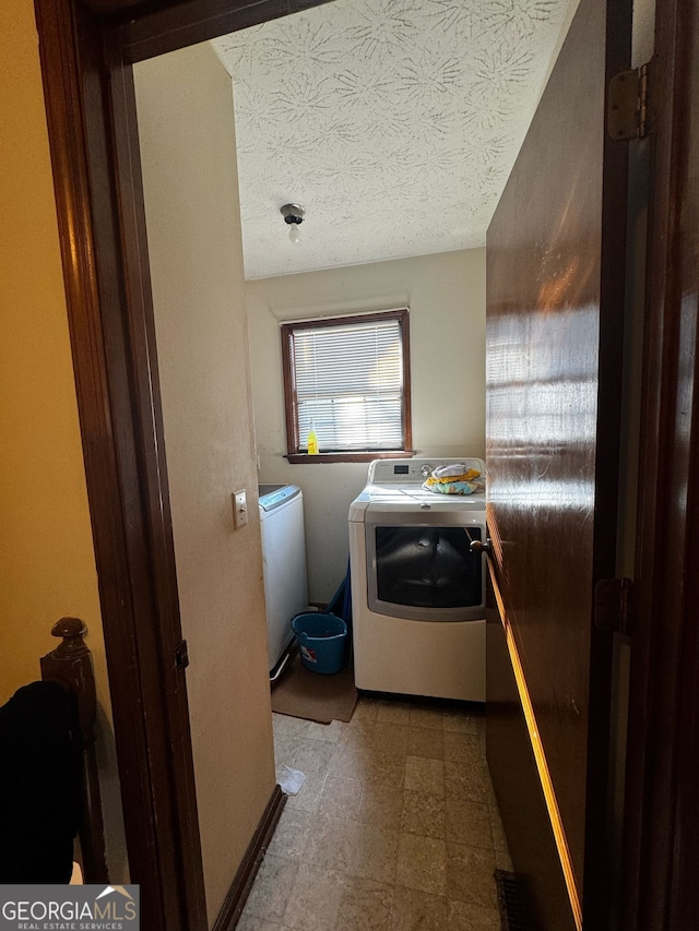 clothes washing area featuring tile patterned floors, separate washer and dryer, laundry area, and a textured ceiling