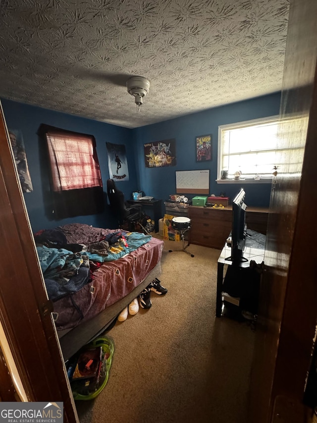 bedroom featuring carpet flooring and a textured ceiling