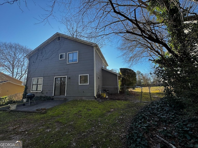 back of house with a patio area, fence, and a lawn