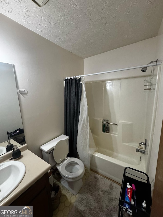 bathroom featuring vanity, toilet, shower / bath combo with shower curtain, and a textured ceiling