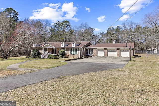 view of front of property with driveway, fence, a front yard, a garage, and brick siding