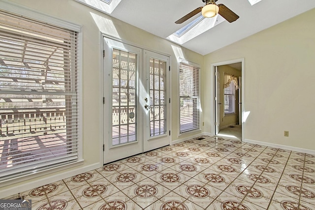 doorway to outside with lofted ceiling with skylight, a ceiling fan, french doors, light tile patterned floors, and baseboards