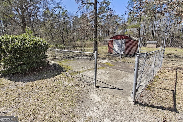 view of yard featuring a storage unit, an outdoor structure, and fence