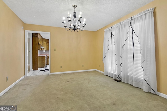 unfurnished dining area with a notable chandelier, baseboards, carpet floors, and a textured ceiling