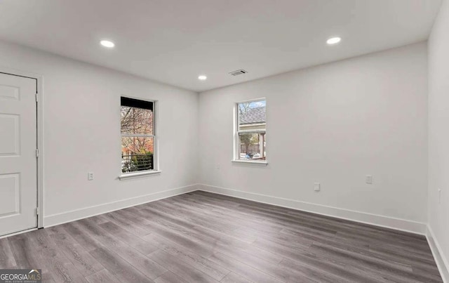 unfurnished room with recessed lighting, visible vents, baseboards, and wood finished floors