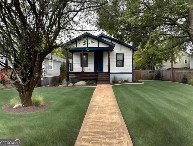 bungalow-style home with a front lawn and fence