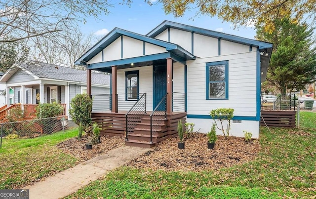 bungalow-style home featuring a front lawn, covered porch, and crawl space