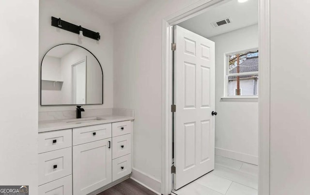 bathroom featuring visible vents, baseboards, and vanity