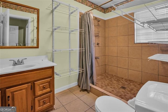 full bathroom with tile patterned floors, tiled shower, toilet, and vanity