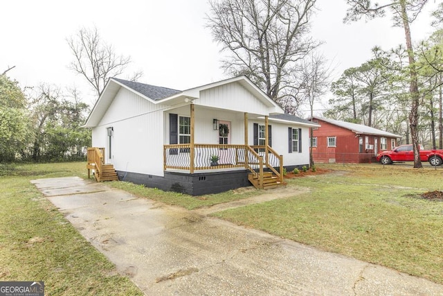 view of front of property featuring a front lawn, covered porch, roof with shingles, and crawl space