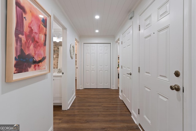 hallway featuring baseboards, recessed lighting, dark wood-style flooring, ornamental molding, and wooden ceiling