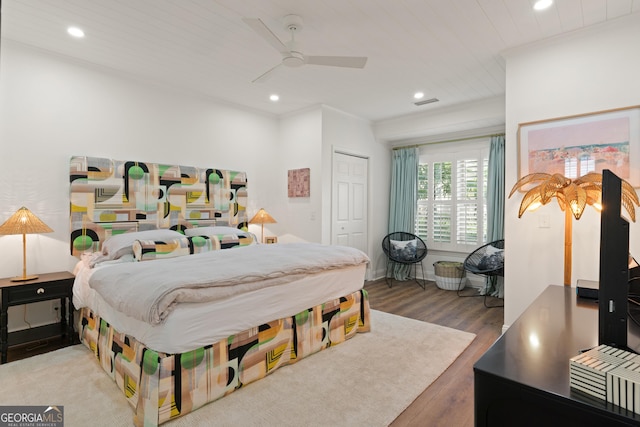 bedroom with crown molding, ceiling fan, recessed lighting, wood finished floors, and a closet