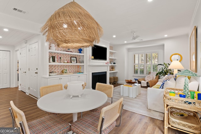 dining room with visible vents, recessed lighting, a fireplace, light wood-style floors, and a ceiling fan