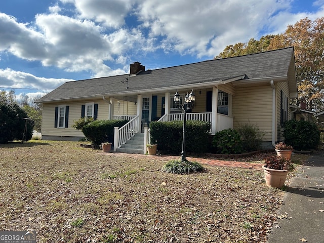 single story home with a porch and a chimney