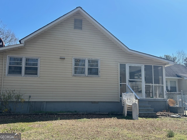 view of property exterior featuring crawl space, a lawn, and a sunroom