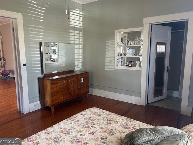 bedroom featuring baseboards and dark wood finished floors