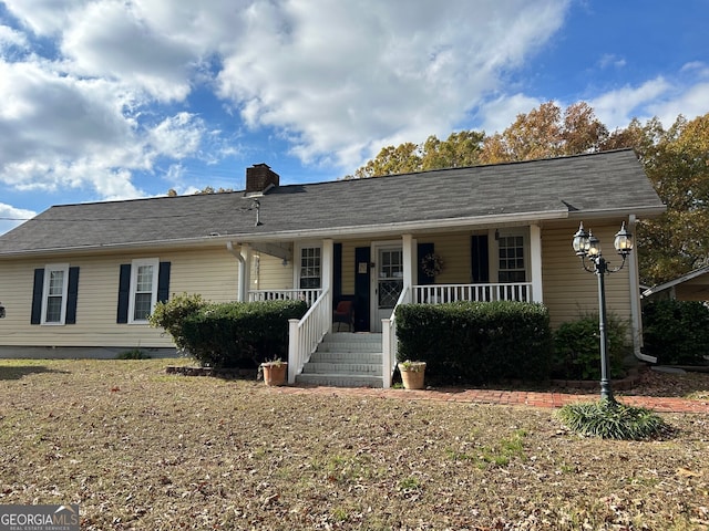 single story home featuring a porch and a chimney