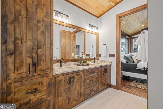 full bath featuring connected bathroom, wood ceiling, vaulted ceiling, wood finished floors, and a sink