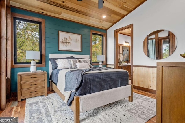 bedroom with multiple windows, lofted ceiling, wooden ceiling, and light wood finished floors