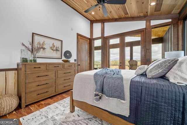 bedroom featuring french doors, light wood-style floors, wainscoting, wood ceiling, and vaulted ceiling