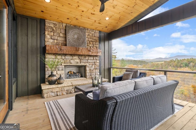 deck with an outdoor living space with a fireplace and a mountain view