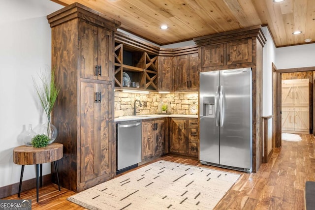 kitchen featuring light countertops, wood ceiling, light wood-style floors, and appliances with stainless steel finishes