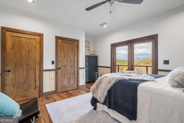 bedroom with wood finished floors, visible vents, access to exterior, french doors, and wainscoting