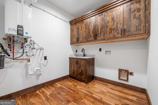 laundry room featuring light wood-style flooring, cabinet space, tankless water heater, baseboards, and hookup for an electric dryer