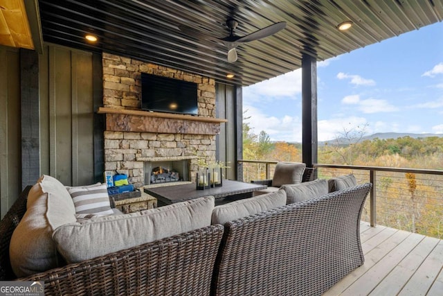 wooden deck featuring an outdoor living space with a fireplace and a ceiling fan