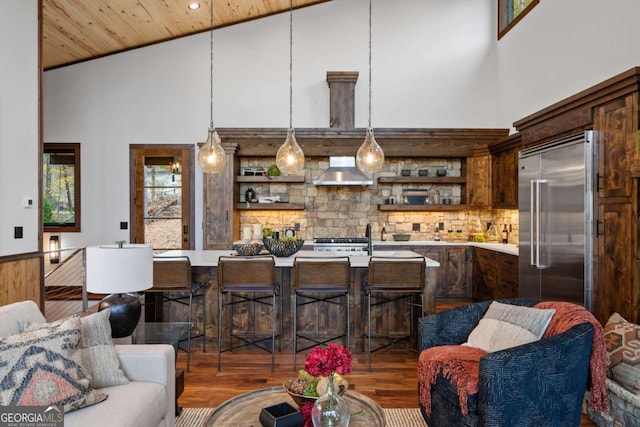 living area featuring wood finished floors, a towering ceiling, and wooden ceiling