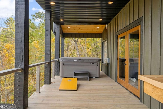 deck with french doors and a hot tub