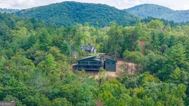 birds eye view of property featuring a mountain view and a view of trees