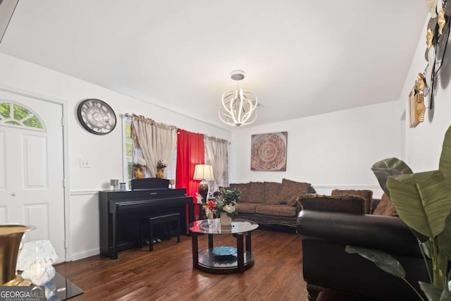 living area featuring baseboards, an inviting chandelier, and wood finished floors