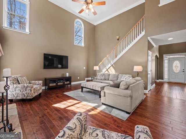 living room with arched walkways, ornamental molding, baseboards, and hardwood / wood-style flooring