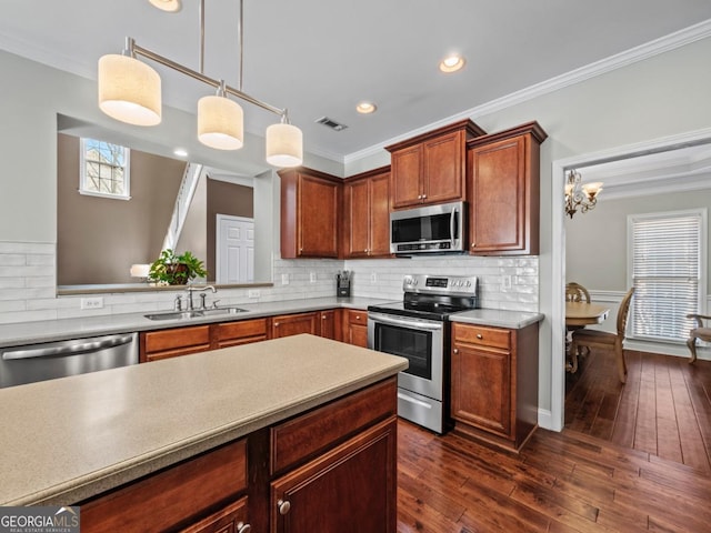 kitchen featuring a sink, stainless steel appliances, visible vents, and ornamental molding