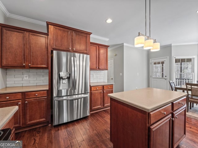 kitchen featuring dark wood-style flooring, ornamental molding, light countertops, and stainless steel fridge with ice dispenser