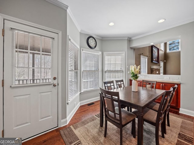 dining space featuring dark wood-style floors, visible vents, baseboards, recessed lighting, and crown molding