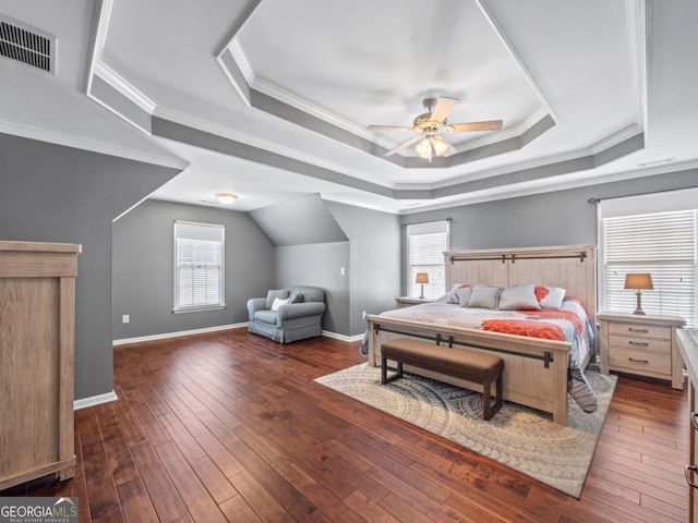 bedroom with visible vents, ornamental molding, a tray ceiling, and wood-type flooring