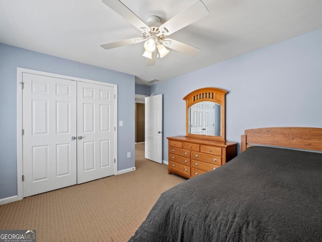 bedroom with visible vents, baseboards, ceiling fan, a closet, and light colored carpet