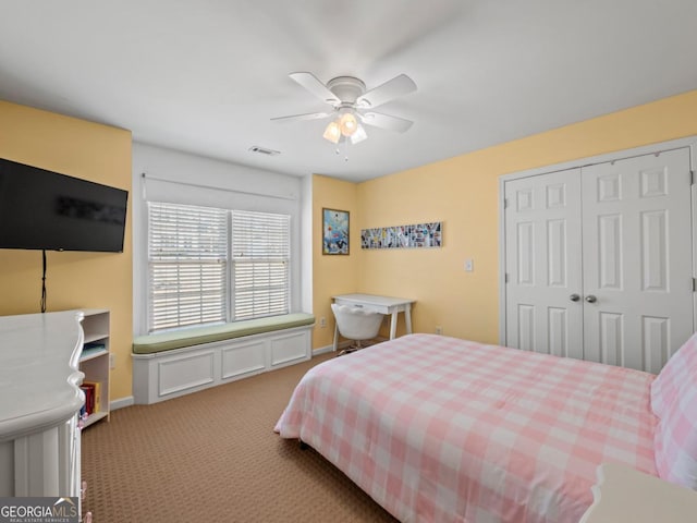 carpeted bedroom with a closet, baseboards, visible vents, and a ceiling fan