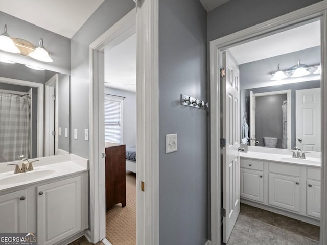 ensuite bathroom featuring a sink, two vanities, and ensuite bathroom