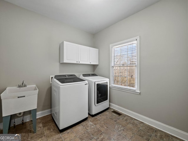 laundry room featuring visible vents, cabinet space, baseboards, and washer and clothes dryer