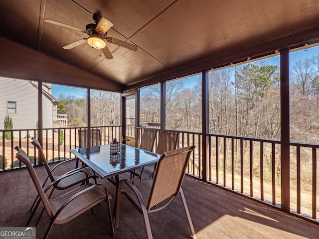 unfurnished sunroom featuring vaulted ceiling and a ceiling fan