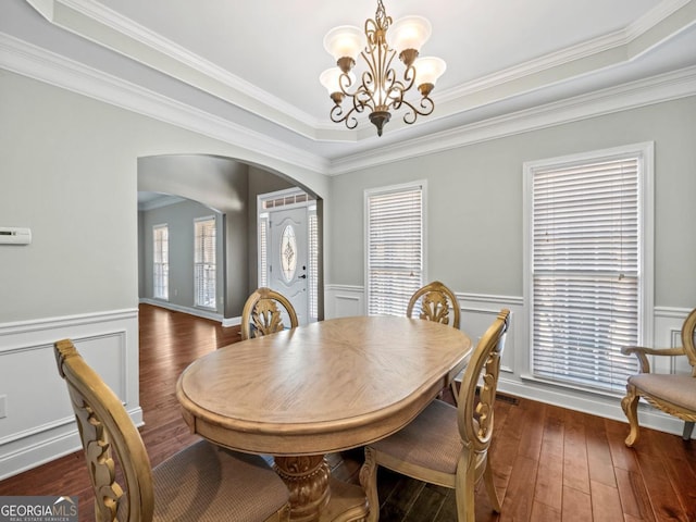 9035 Forest Path Dr, Gainesville, GA 30506 - dining area featuring arched walkways, a chandelier, a wainscoted wall, wood-type flooring, and crown molding