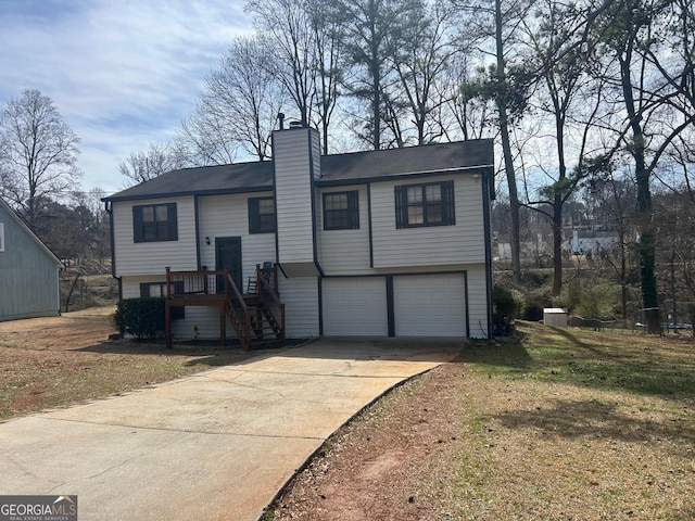 bi-level home featuring a garage, concrete driveway, and a chimney