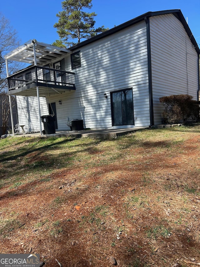 rear view of house featuring central air condition unit and a deck