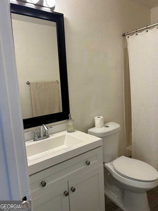 full bath with toilet, vanity, and a shower with shower curtain