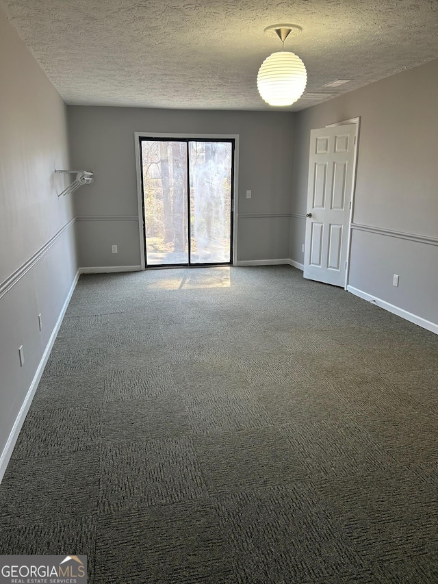 unfurnished room featuring baseboards, a textured ceiling, and carpet flooring