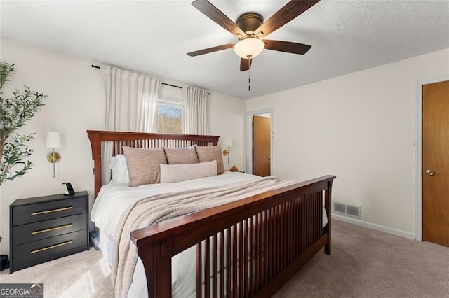 bedroom featuring a ceiling fan, baseboards, visible vents, a textured ceiling, and carpet flooring